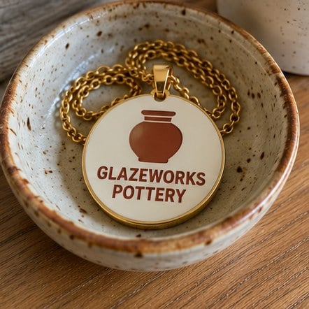 Branded enamel pendant in a ceramic dish